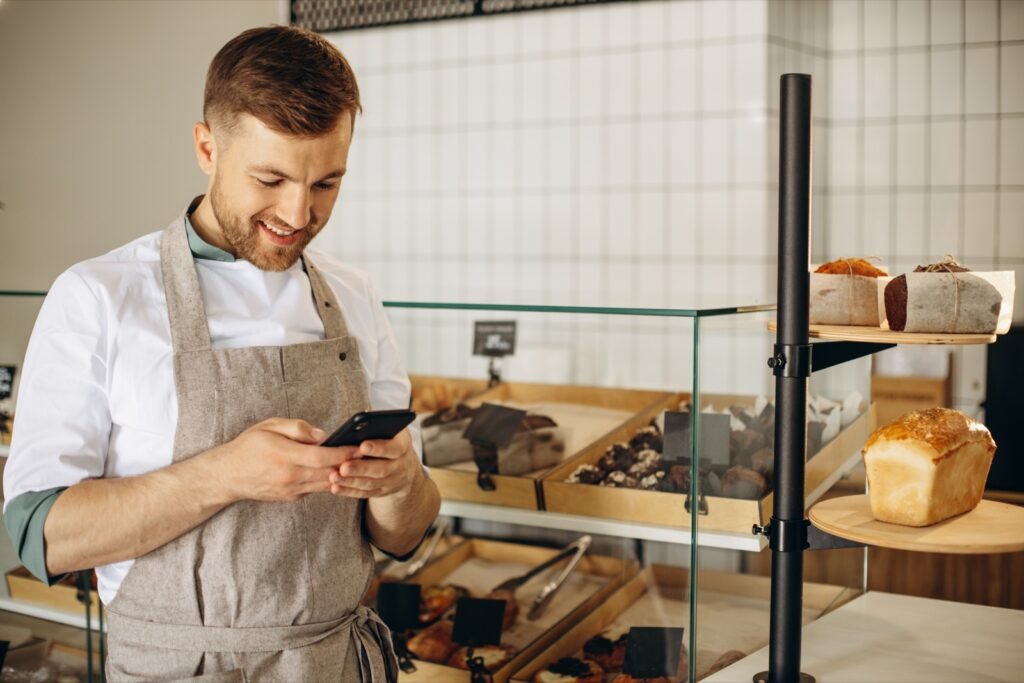 Boulanger au comptoir de sa boutique, au téléphone